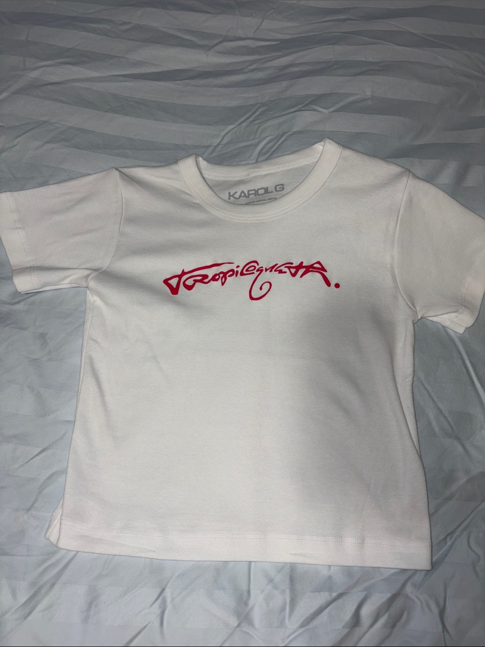 Karol G Tropicoqueta White Graphic Tee with Pink Script Logo - Baby Tee